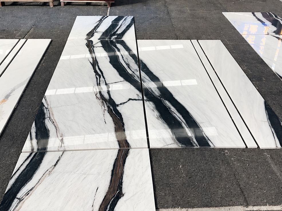 Polished Panda White marble cut-to-size panels laid out on a workshop floor