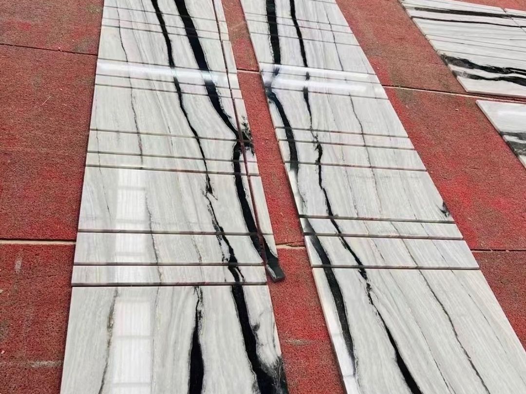 Two groups of polished Panda White marble strips with directional black vein lines